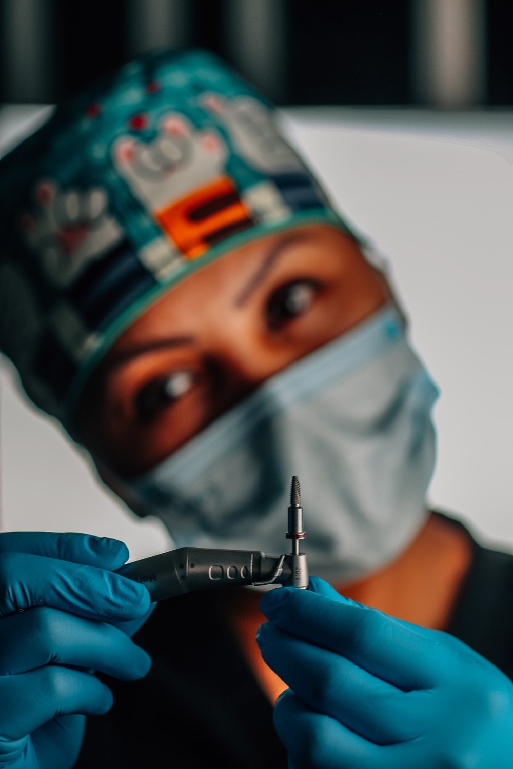A clinician holding the handpiece with the implant driver mounted.
